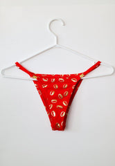 front view of red and gold afro-caribbean inspired yemaya tanga underwear on white hanger